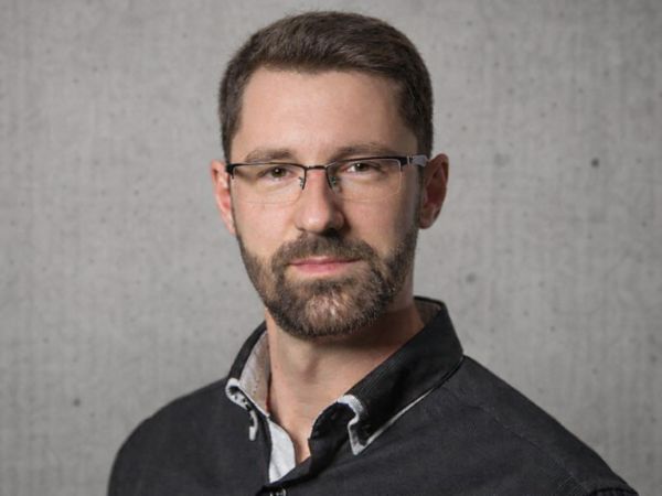 florian-wagner-garten-und-landschaftsbau Mann mit kurzen dunklen Haaren, Brille, Vollbart und schwarzem Hemd