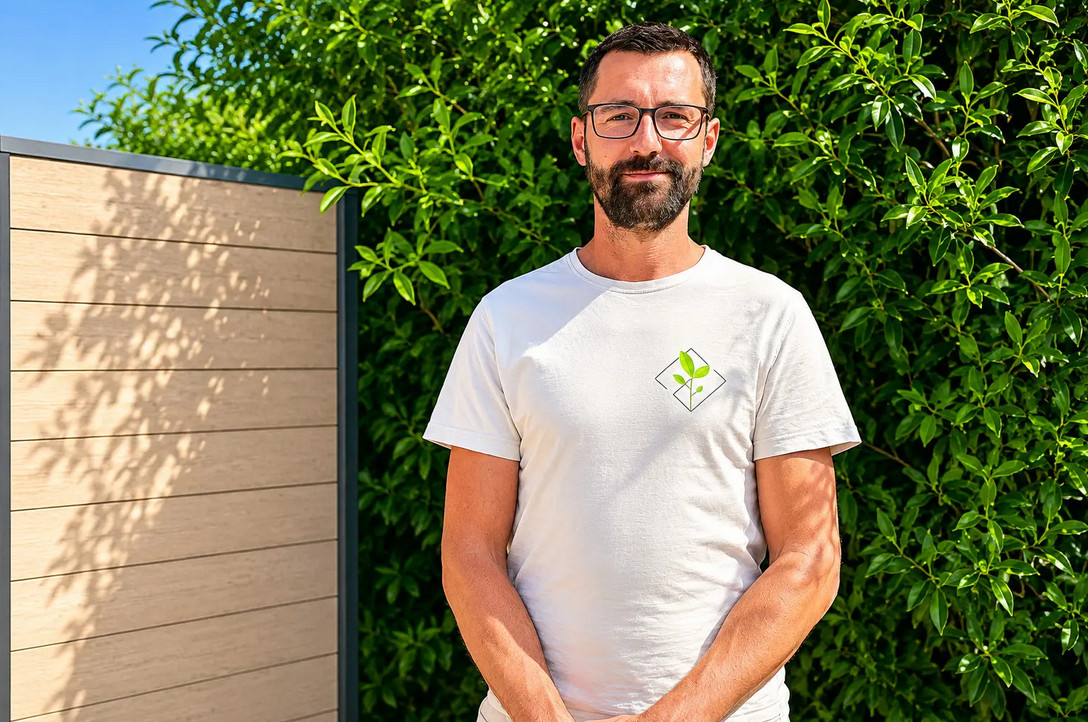 Geschäftsführer Florian Wagner Geschäftsführer eines Garten- und Landschaftsbauunternehmens vor grünem Sichtschutz und moderner Gartenabgrenzung