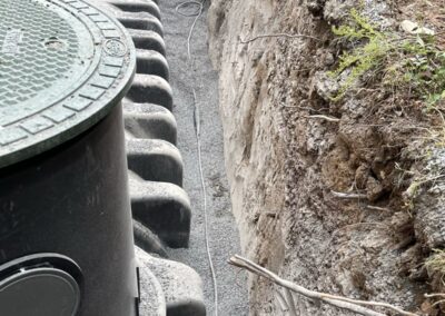 Einbau einer Zisterne mit vorbereitetem Graben und Leitungsführung im Gartenbereich